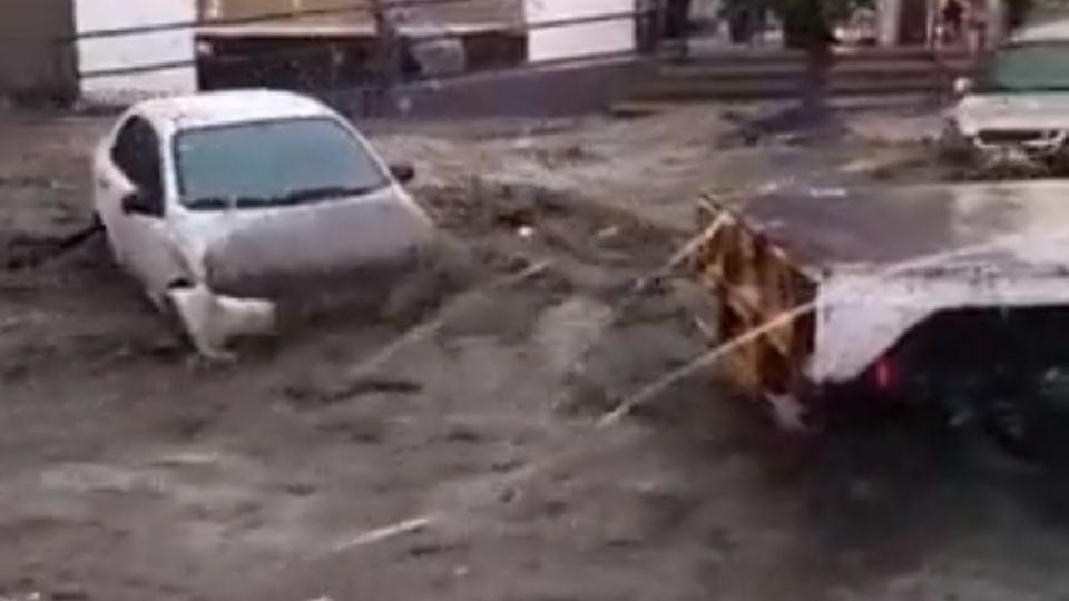 Vehículos estacionados en vía pública fueron arrastrados por las inundaciones. Foto: Cortesía