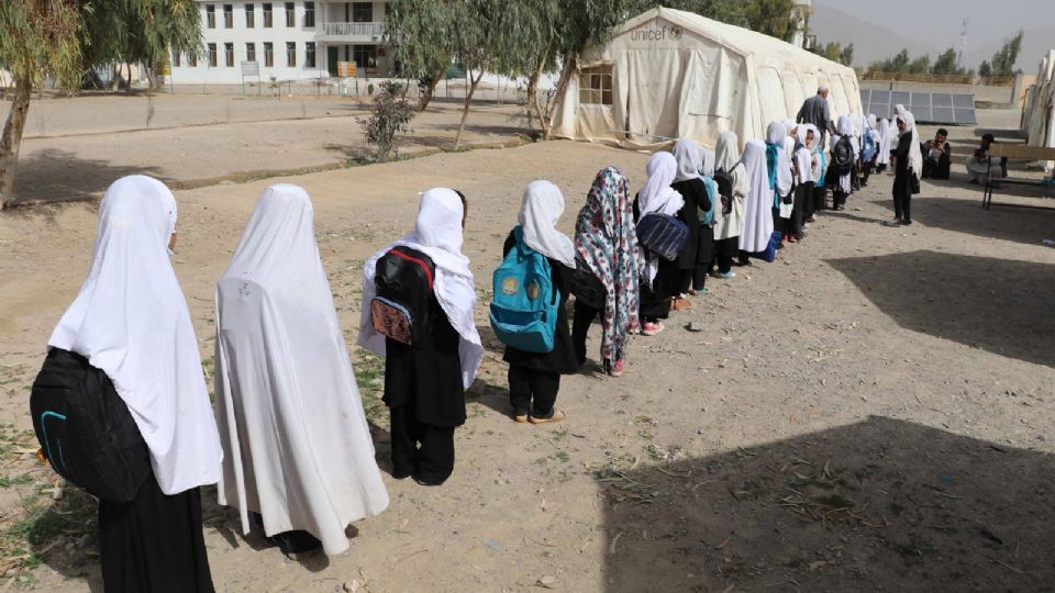 Niñas con mochila se dirigen a la escuela.