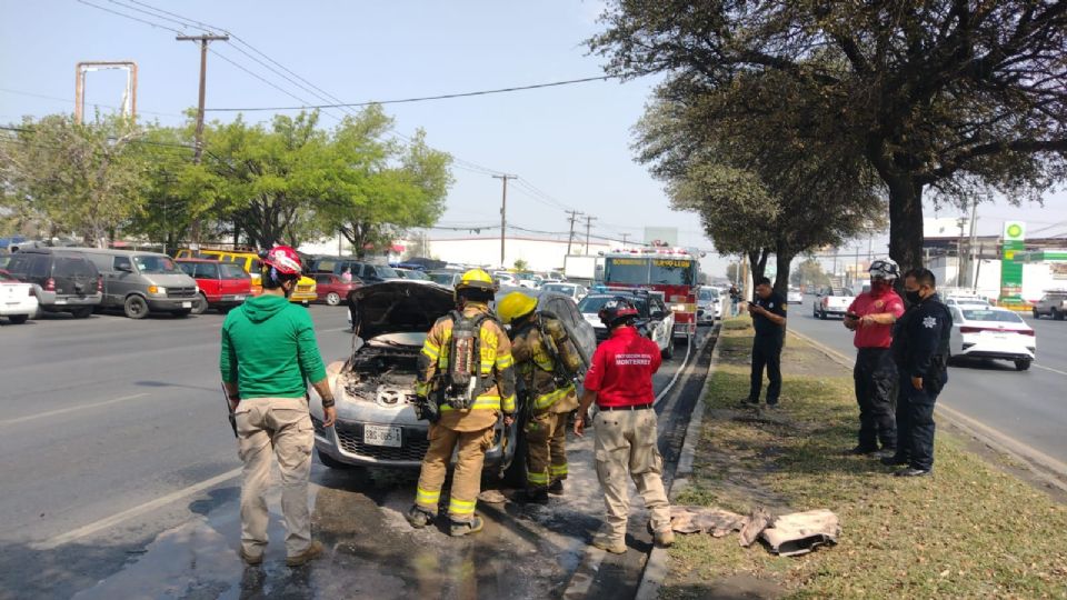 Elementos de Bomberos atienden al auto afectado.