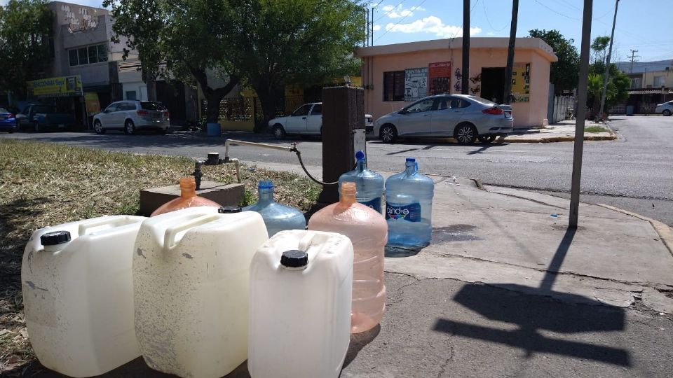 Vecinos recurren a llaves municipales para recaudar agua.