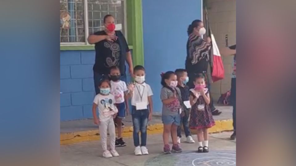 Pequeños estudiantes 'saludando' a la bandera. Foto: Captura de pantalla / Facebook / Erica Patricia Montemayor Leal.