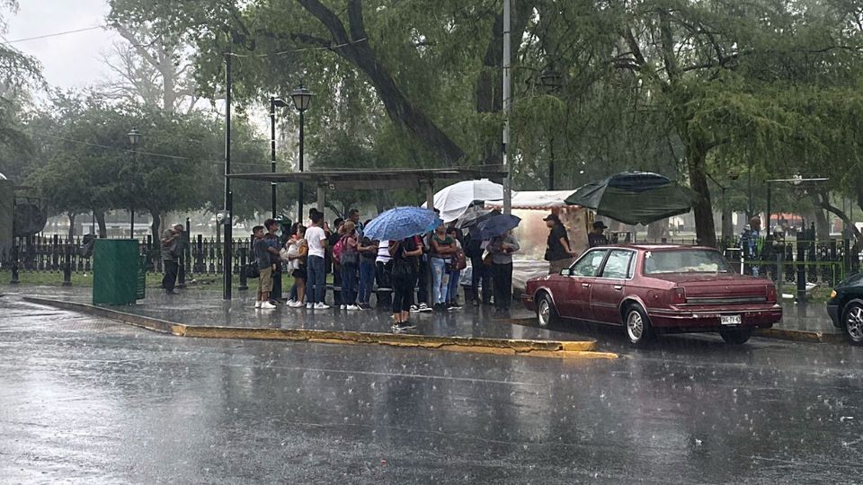 Personas se protegen de una intensa lluvia en el área metropolitana de Monterrey