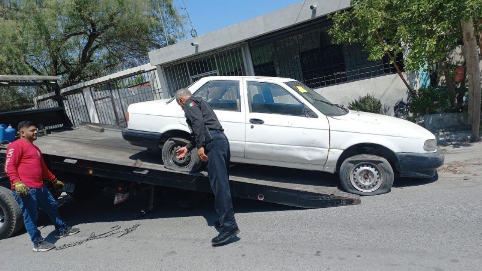 Autoridades retirando un auto abandonado.