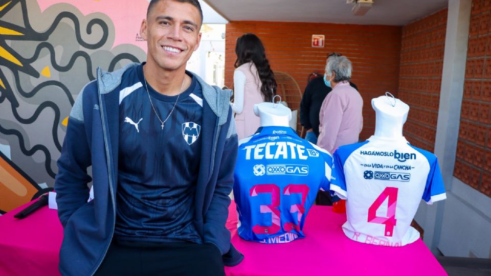 Héctor Moreno posa junto a loa uniformes conmemorativos que estará utilizando el Monterrey para concientizar y sensibilizar sobre el cáncer de mama