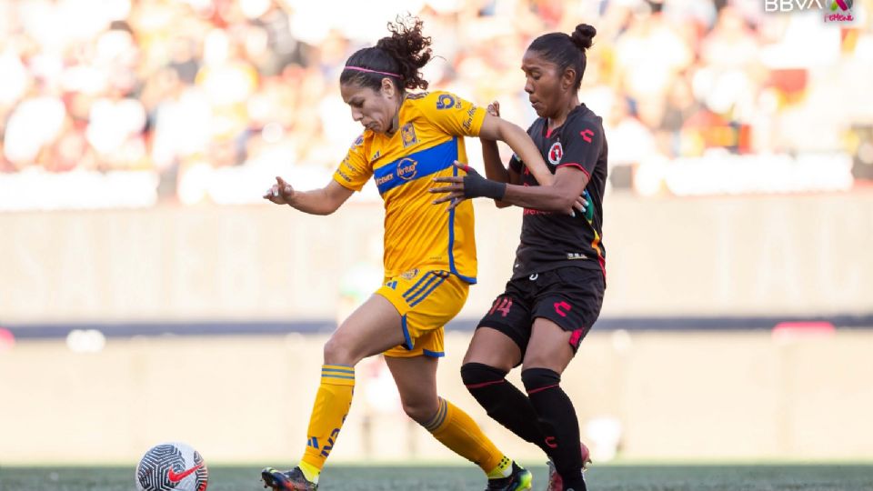 Alexia Delgado disputando el balón ante Tijuana.