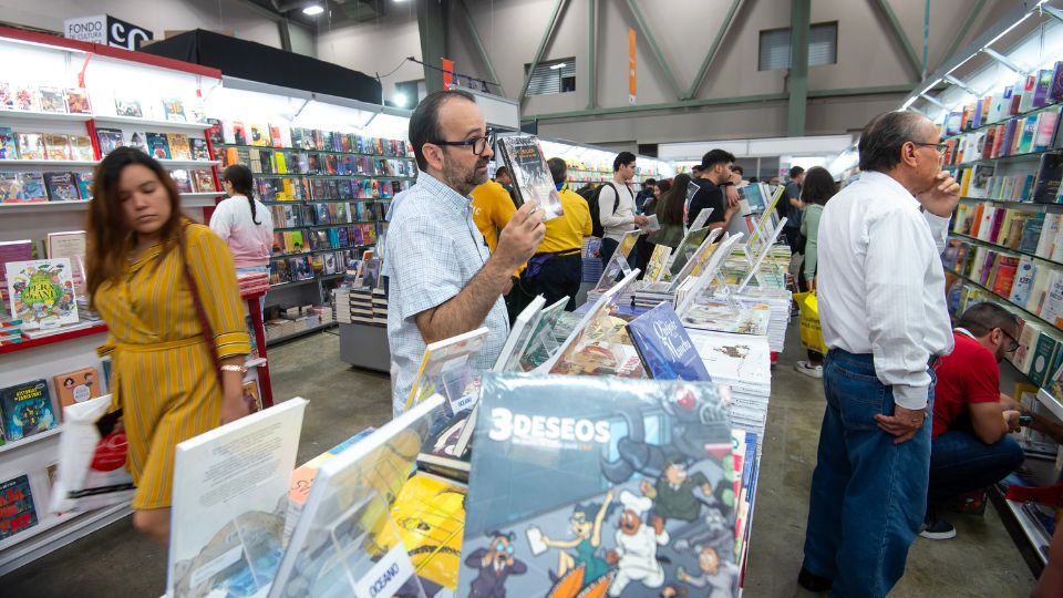 Visitantes observan libros durante la edición 31 de la Feria Internacional del Libro (FIL) en Monterrey.