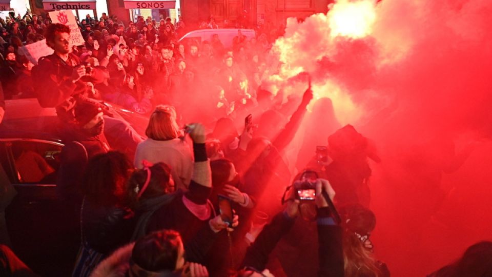 Participantes y activistas de la organización feminista 'Non Una Di Meno' (ni una menos) sostienen bengalas mientras se enfrentan a la policía durante una protesta con motivo del Día Internacional de la Eliminación de la Violencia contra la Mujer