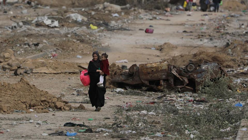 Los palestinos caminan después de cruzar desde el norte de la Franja de Gaza hasta el sur de la Franja de Gaza a lo largo de la carretera Salah Al Din.