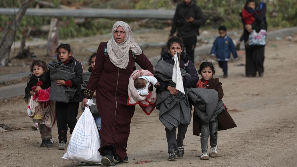 Palestinos caminan después de cruzar desde el norte de la Franja de Gaza al sur de la Franja de Gaza a lo largo de la carretera Salah Al Din en el centro de la Franja de Gaza.