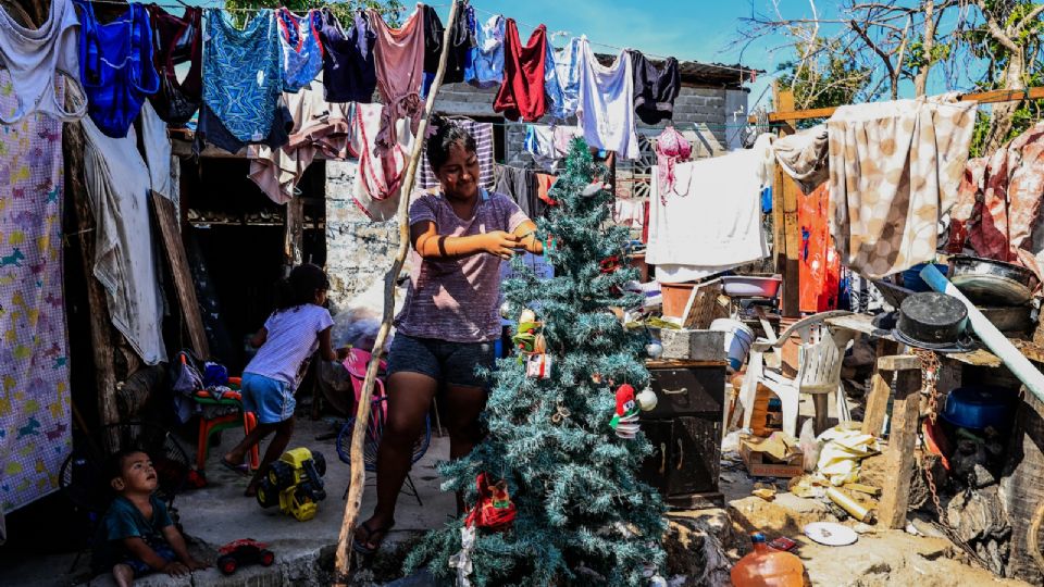 Cristal Ortiz Balderas, habitante de la colonia Cumbres de Figueroa, una de las zonas afectadas por el 'huracán Otis', pone un pino navideño, el 23 de diciembre de 2023, en Acapulco, estado de Guerrero