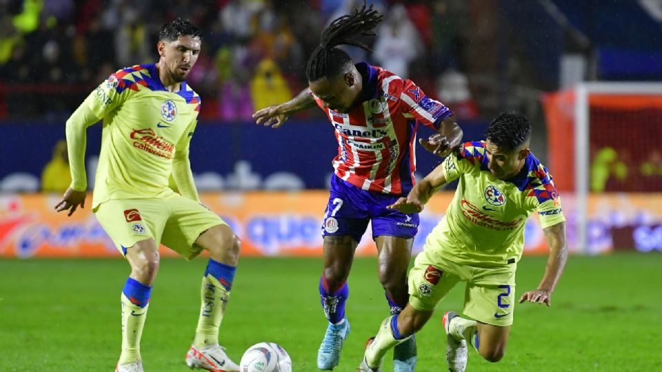 Jhon Murillo del San Luis y Luis Fuentes del América disputan el balón.