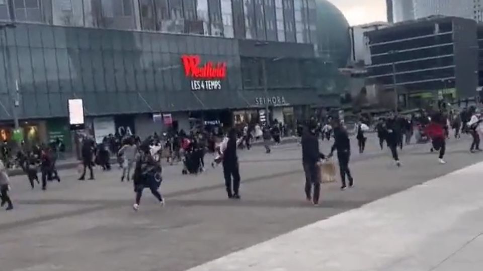 Personas corriendo al exterior del centro comercial en La Défense.