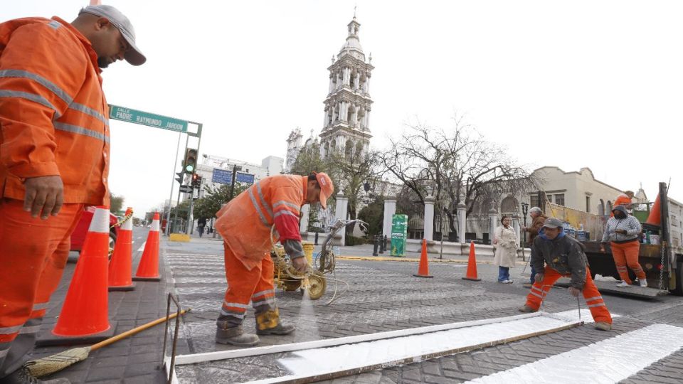 Personal de servicios públicos pintando las líneas divisorias en el Centro de Monterrey.