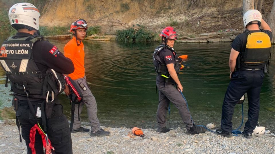 Autoridades en el río donde encontraron el cuerpo del menor muerto.