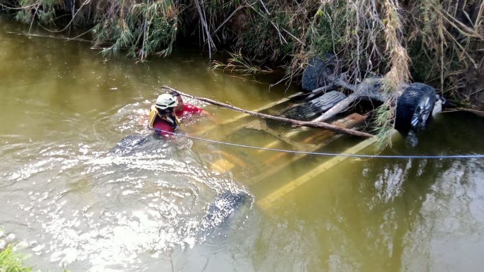 Protección Civil de Nuevo León realizando labores de extracción en acequia.