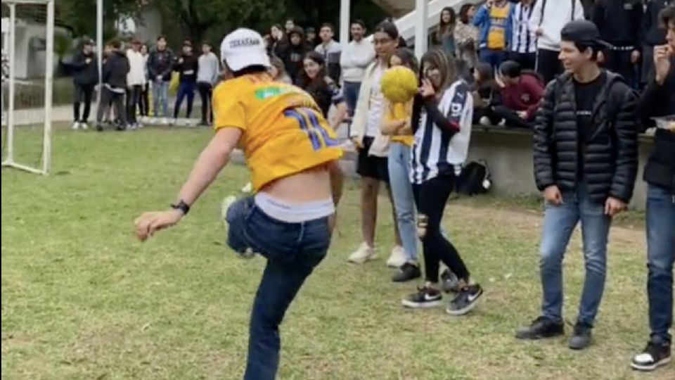 El alumno con el jersey de Tigres intentó lucirse y terminó golpeando accidentalmente a una compañera con el uniforme de Rayados