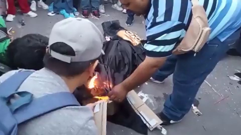 Momento en que un grupo de hombres le prendió fuego a la piñata de Norma Piña.