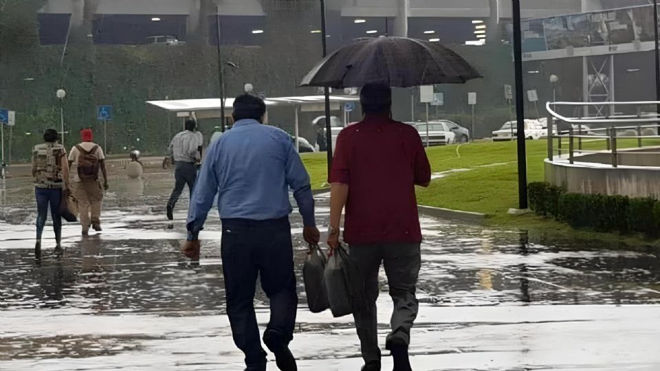 Personas caminando con un paraguas ante lluvia en Monterrey