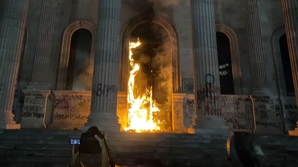 La puerta principal del Palacio de Gobierno de Nuevo León quemándose.