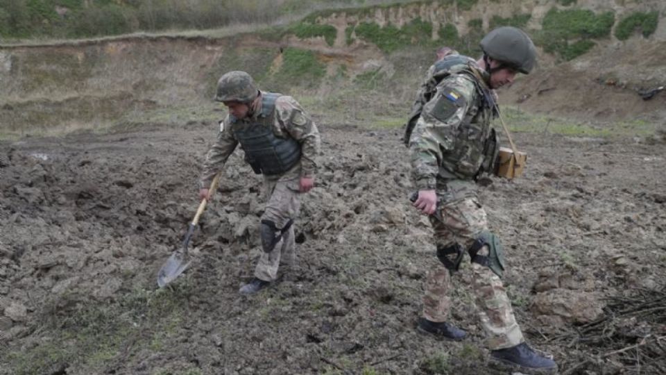 Militares ucranianos inspeccionan un cráter tras la explosión de minas antitanque