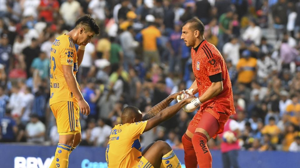 Nahuel Guzmán ayuda a levantarse a Samir Caetano durante el juego ante Querétaro en La Corregidora