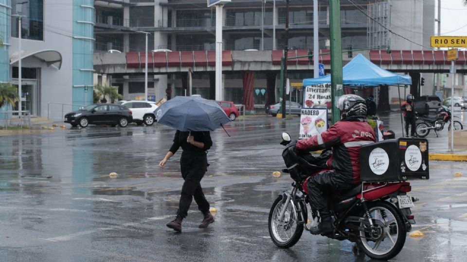 Regia camina por la calle con su paraguas tras la lluvia que caía en la zona