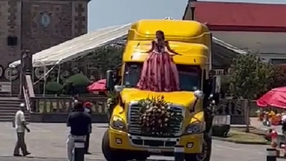 La joven encima del tráiler amarillo.