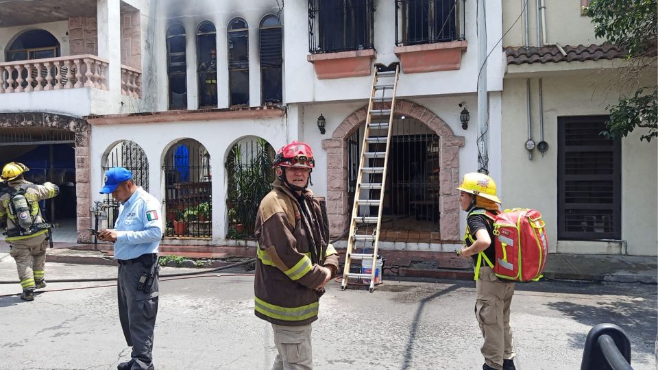 Bomberos de Nuevo León realizando las labores pertinentes para apagar el fuego en la casa.