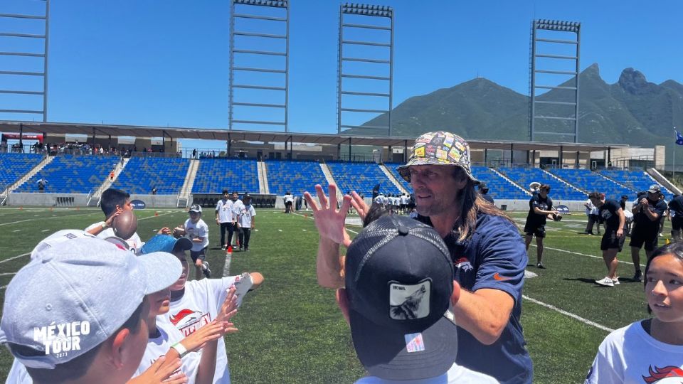 Jake Plummer, ex jugador de los Broncos de Denver, dando indicaciones a jóvenes regios