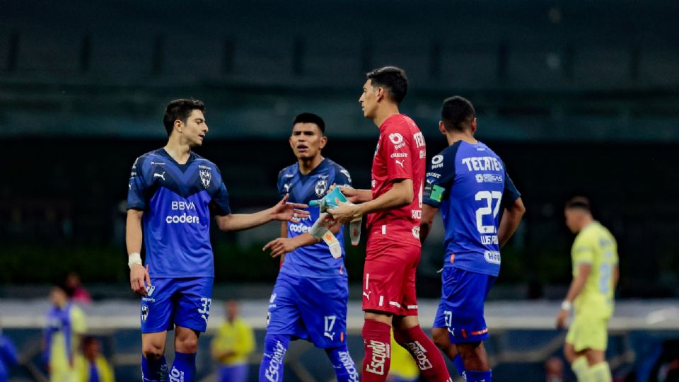 Esteban Andrada entrega sus guantes a Stefan Medina luego de ser expulsado ante América. El colombiano terminó el partido como el portero de Rayados