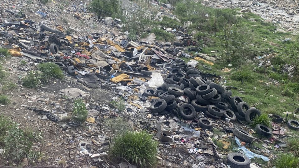 Llantas, basura y escombro son los materiales que se desechan en el lecho del río Pesquería.