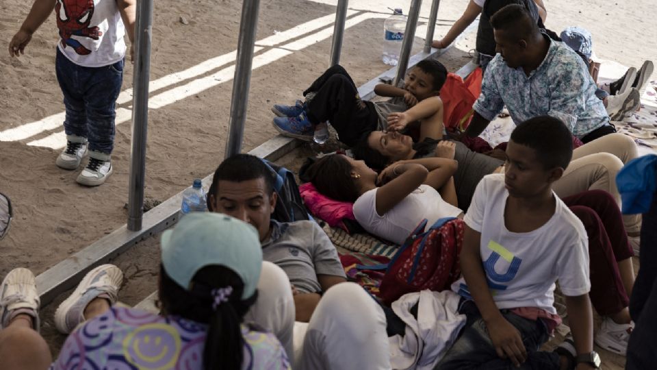 Una familia de migrantes de Colombia esperando ser llevados por agentes de la Patrulla Fronteriza a un centro de procesamiento en la frontera de México y Estados Unidos.