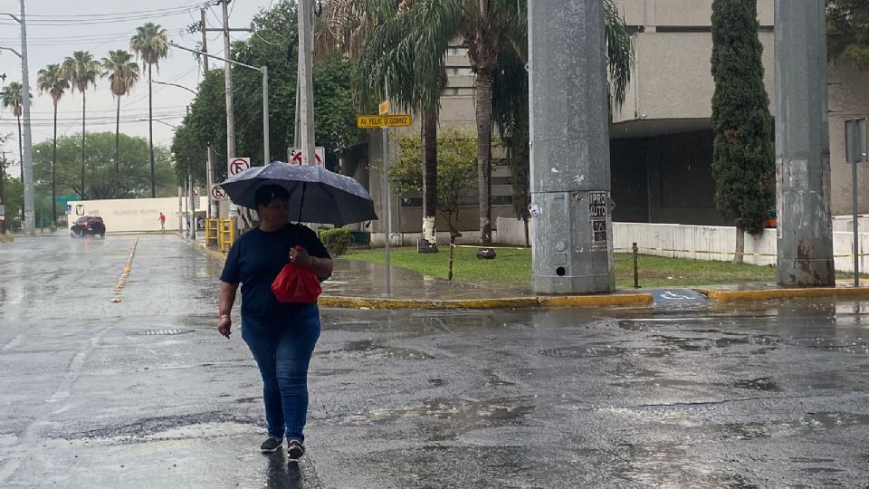 Persona con paragua caminando mientras llueve en Monterrey