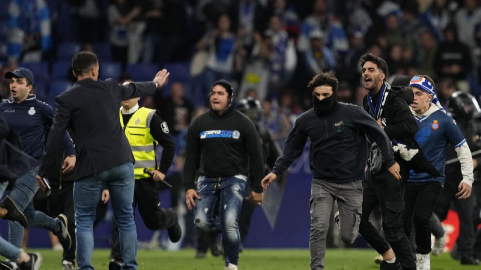 Ultras blanquiazules empezaron a saltar al campo y se inició una lluvia de objetos que obligó la intervención de las autoridades y el resguardo de los jugadores del Barcelona.