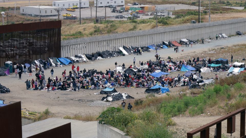 Migrantes junto al muro fronterizo el 12 de mayo de 2023, en la ciudad de Tijuana.