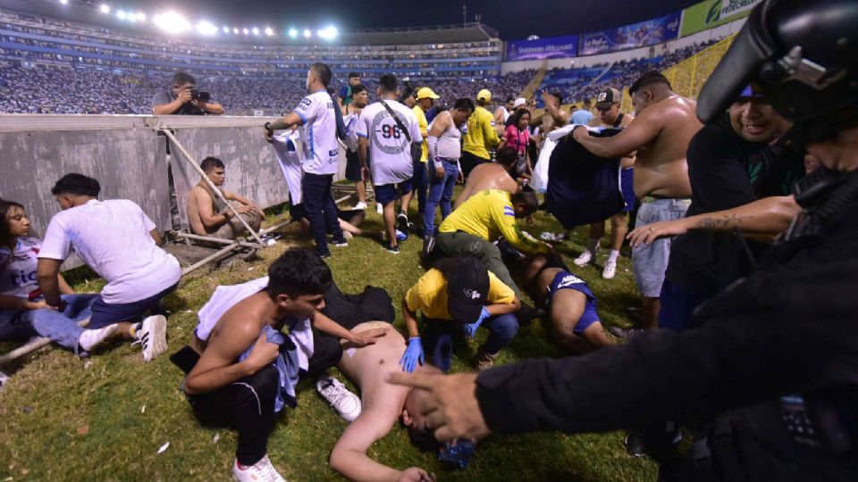 náticos auxilian a personas durante una estampida en el Estadio Cuscatláán previo a un partido de la Liga Mayor, hoy en San Salvador