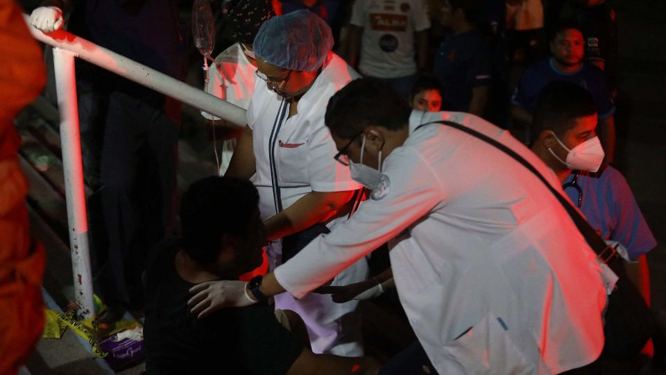 Médico atendiendo a un herido de la estampida en el Estadio Cuscatlán, en El Salvador.