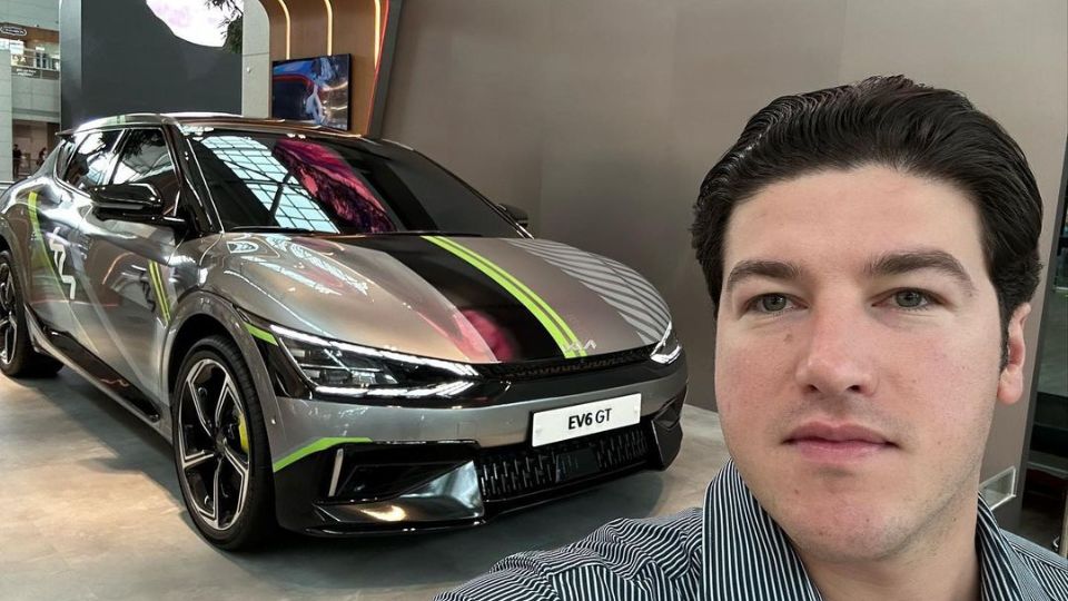 Samuel García al lado del automóvil eléctrico de Kia, EV 6 GT.