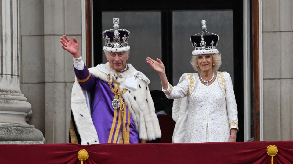 El Rey Carlos III (L) y la Reina Camila de Gran Bretaña se paran en el balcón del Palacio de Buckingham después de su Coronación en Londres