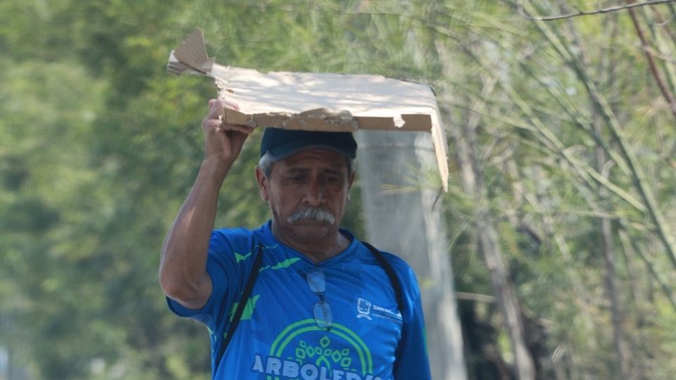 Persona cubriéndose del sol tras altas temperaturas en NL