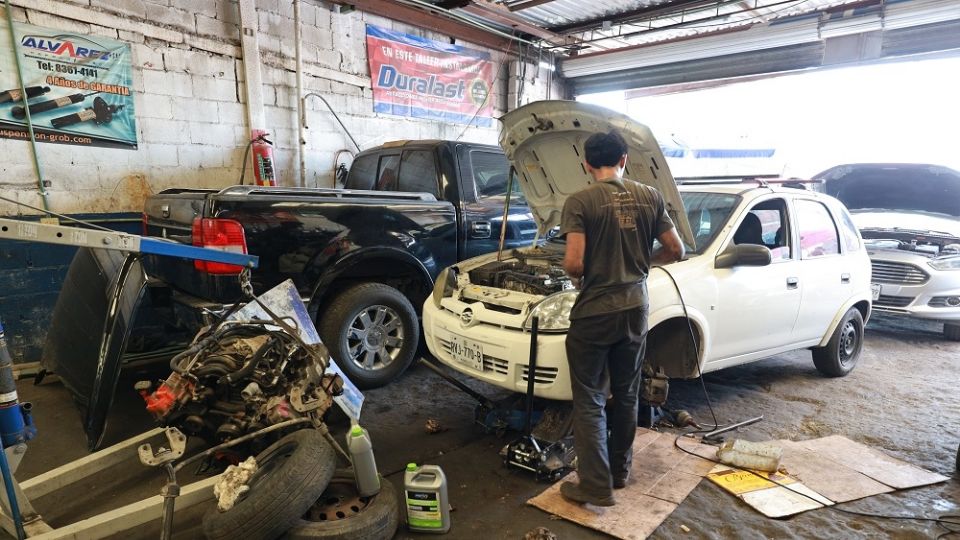 Mecánico arreglando un auto tras sufrir daños por el calor extremo que se vive en Nuevo León