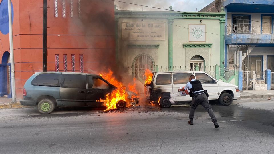 Oficiales sofocan incendio de vehículos.