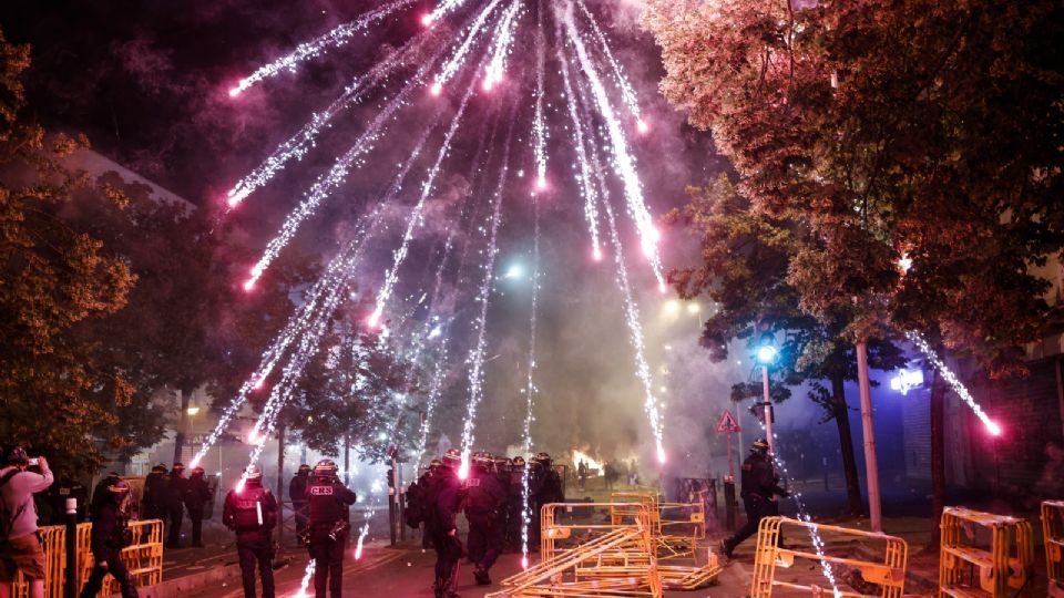 Los manifestantes arrojan fuegos artificiales a la policía antidisturbios durante los enfrentamientos en Nanterre, cerca de París, Francia.