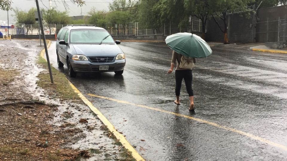 Joven caminando con paraguas