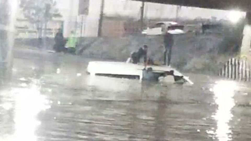 Combi inundada con pasajeros a bordo en Naucalpan.