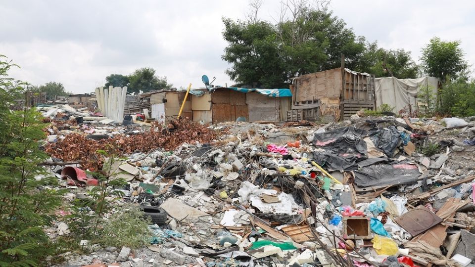 El cauce del río está flanqueado por cerros de basura que llevan camiones