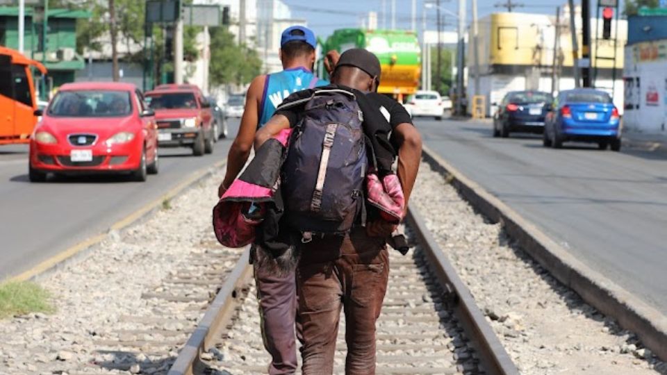 Migrantes caminan sobre las vías del tren en Nuevo León