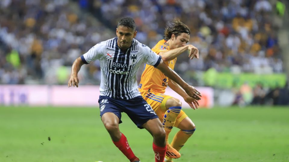 Luis Romo y Sebastián Córdova disputan un balón en en Clásico Regio 131, en la cancha del Estadio BBVA