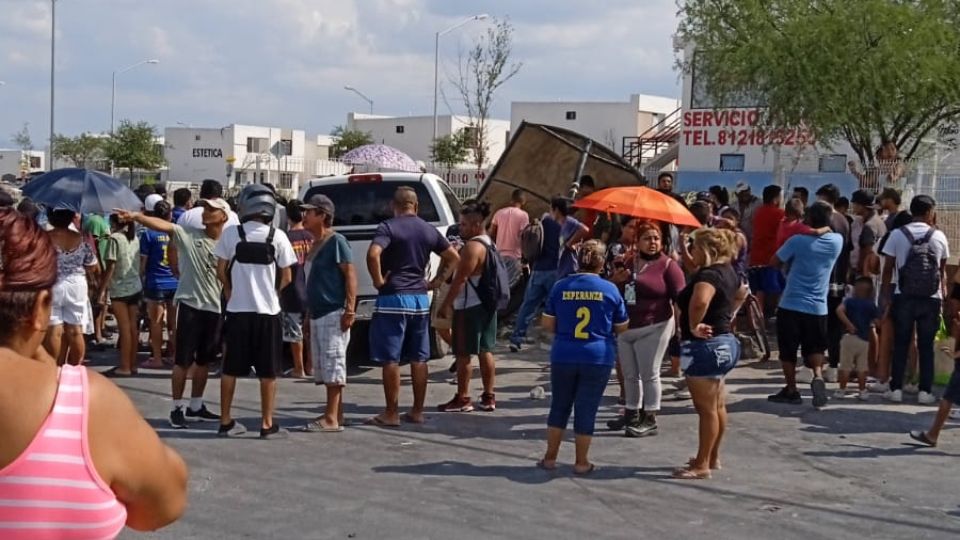 Personas en parada de camiones en Juárez.