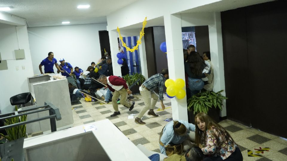 Asistentes en el mitin se resguardan durante el tiroteo.